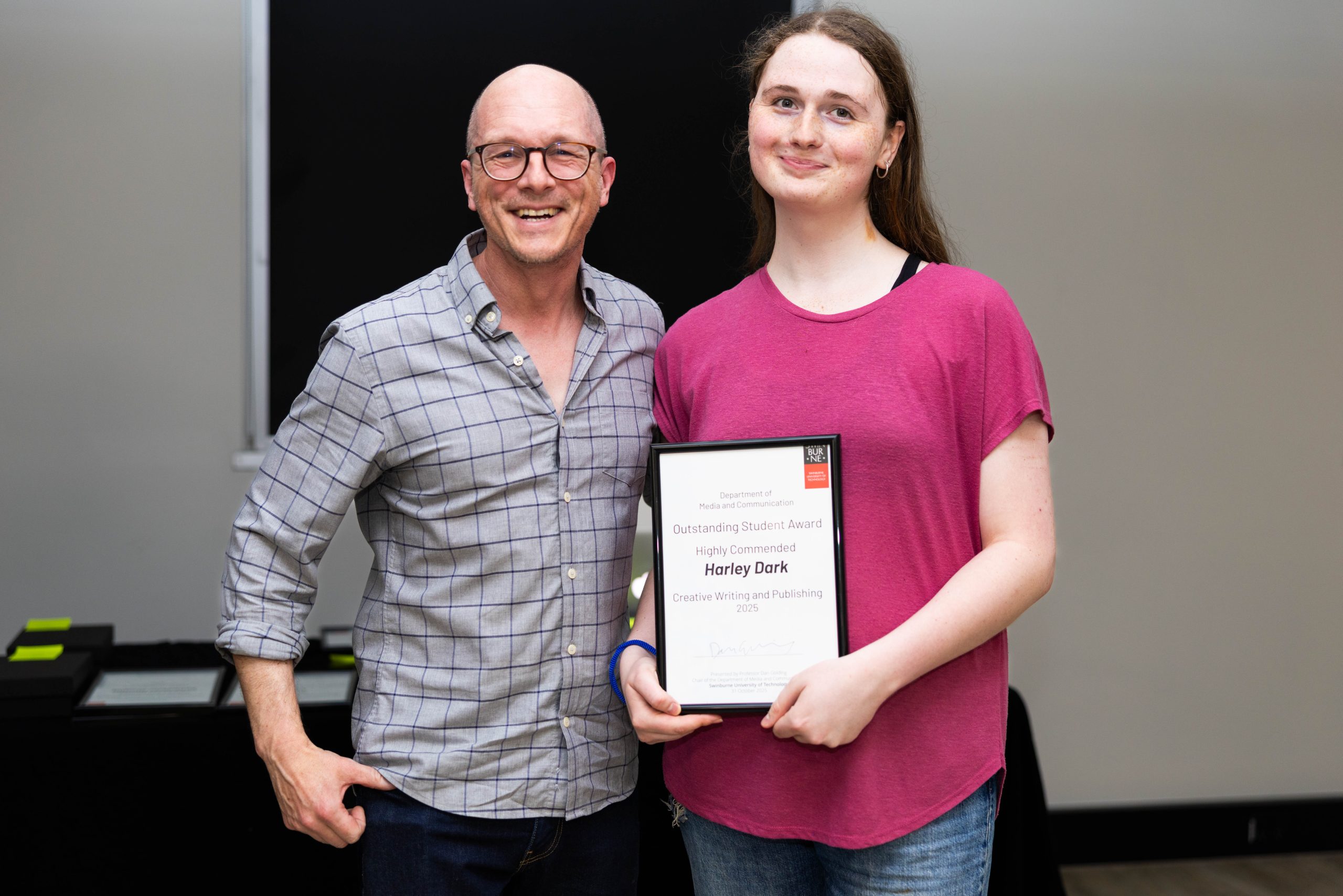 Harley Dark holding the Highly Commended for the Outstanding Student Award award, with one of her tutors.